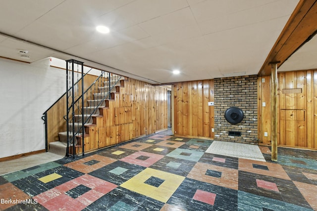 finished below grade area featuring wooden walls, baseboards, stairs, recessed lighting, and tile patterned floors