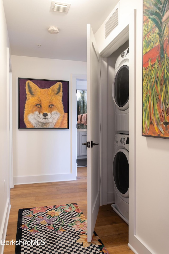 34 Bridge St Unit 201, Great Barrington, MA 01230 - laundry area featuring stacked washer / drying machine and light wood finished floors