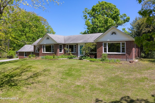 ranch-style house featuring brick siding and a front lawn