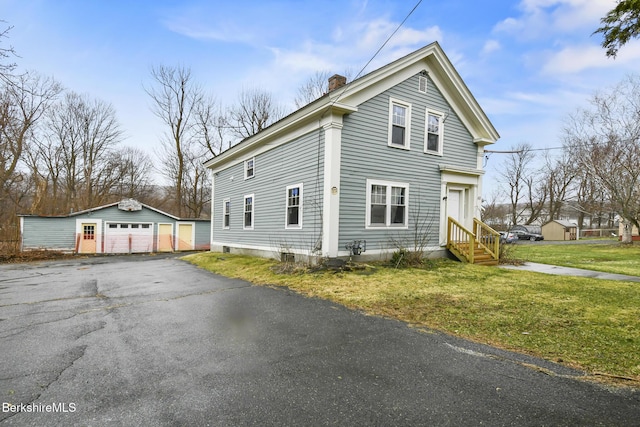111 Columbia St, Adams, MA 01220 - view of property exterior featuring an outbuilding, aphalt driveway, a yard, a chimney, and a garage