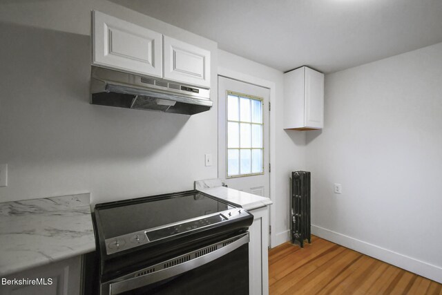 111 Columbia St, Adams, MA 01220 - kitchen with black electric range, baseboards, under cabinet range hood, white cabinetry, and light wood-style flooring