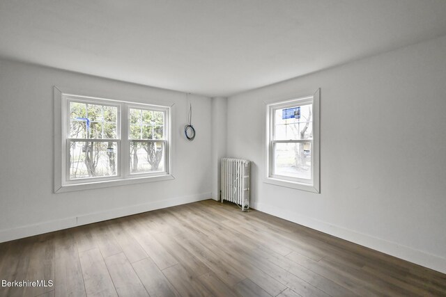 111 Columbia St, Adams, MA 01220 - empty room with wood finished floors, radiator heating unit, baseboards, and a healthy amount of sunlight