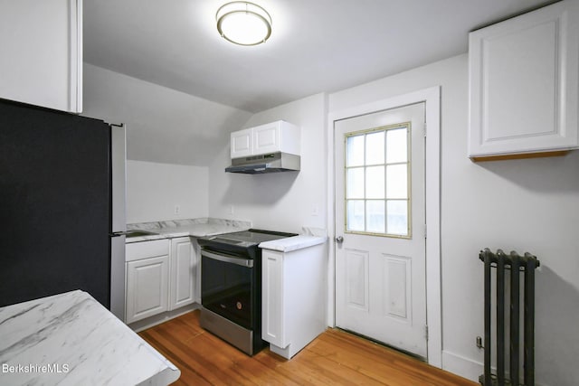 111 Columbia St, Adams, MA 01220 - kitchen featuring white cabinetry, under cabinet range hood, radiator, appliances with stainless steel finishes, and wood finished floors