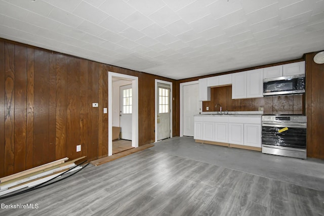 111 Columbia St, Adams, MA 01220 - kitchen with wooden walls, stainless steel microwave, white cabinetry, and stove