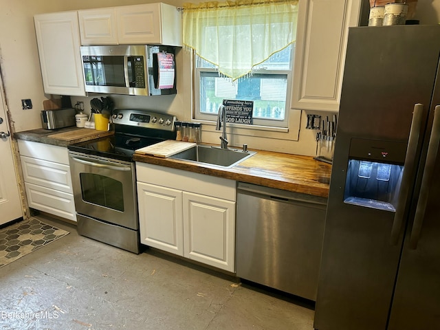 89-91 N Summer St, Adams, MA 01220 - kitchen featuring appliances with stainless steel finishes, wood counters, white cabinetry, and concrete flooring