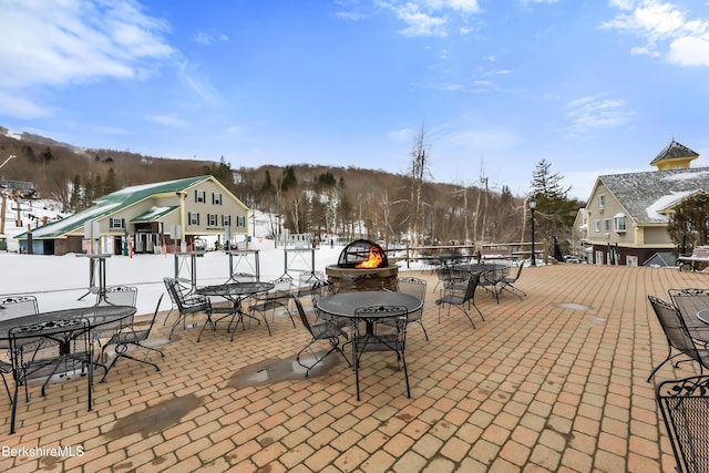 snow covered patio featuring an outdoor fire pit