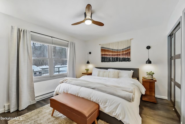 bedroom featuring dark wood-type flooring, a baseboard radiator, and ceiling fan