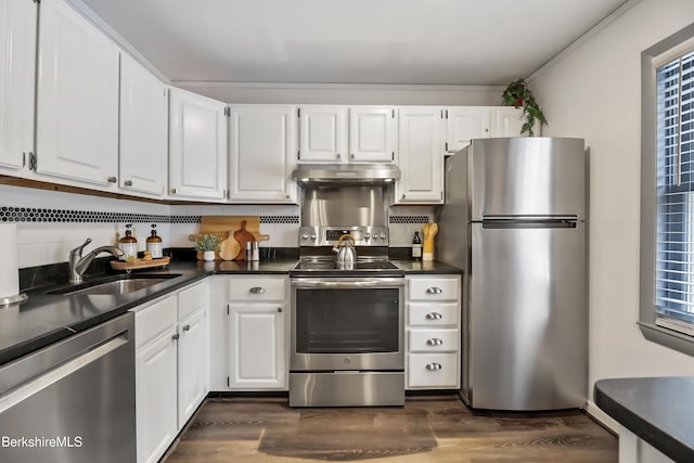 kitchen featuring sink, dark wood-type flooring, appliances with stainless steel finishes, white cabinetry, and backsplash