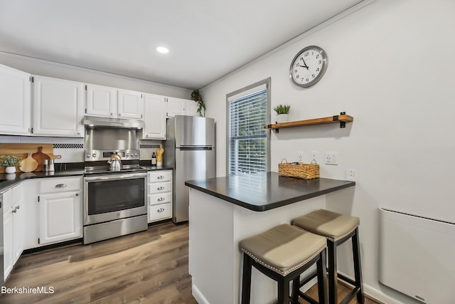 kitchen featuring stainless steel appliances, white cabinets, and kitchen peninsula