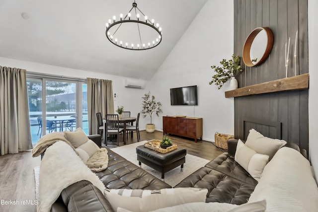 living room featuring a wall mounted AC, high vaulted ceiling, a notable chandelier, hardwood / wood-style flooring, and a fireplace