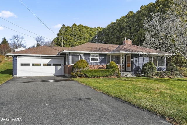 ranch-style house featuring a front lawn and a garage