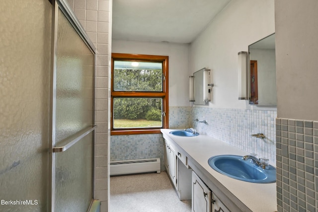 bathroom featuring vanity, a shower with door, baseboard heating, and tile walls