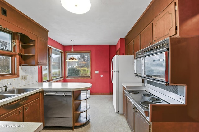 kitchen featuring backsplash, sink, pendant lighting, white refrigerator, and dishwasher