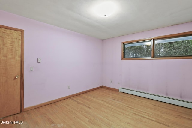 empty room featuring light wood-type flooring and a baseboard radiator