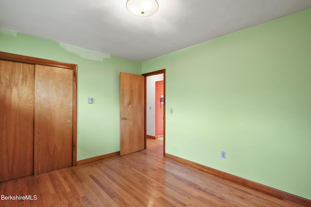 unfurnished bedroom with a closet and light hardwood / wood-style floors