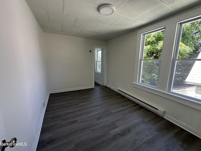 unfurnished room with a baseboard radiator and dark hardwood / wood-style floors