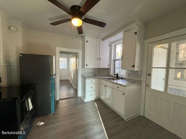 kitchen with sink, white cabinetry, electric range, dark hardwood / wood-style floors, and ornamental molding