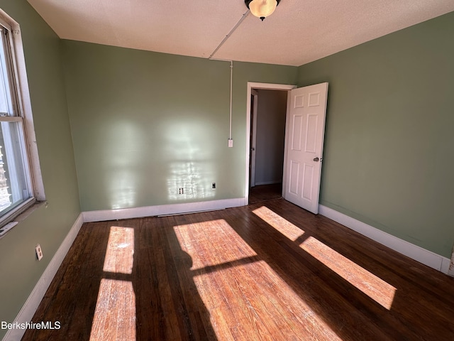 unfurnished room with dark hardwood / wood-style floors