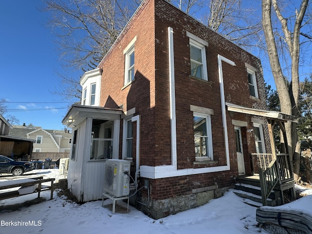 snow covered property featuring ac unit