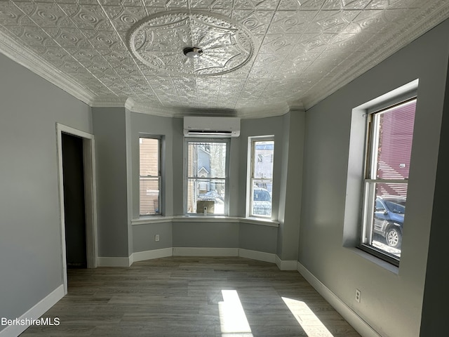 empty room featuring crown molding, a wall mounted air conditioner, and hardwood / wood-style floors