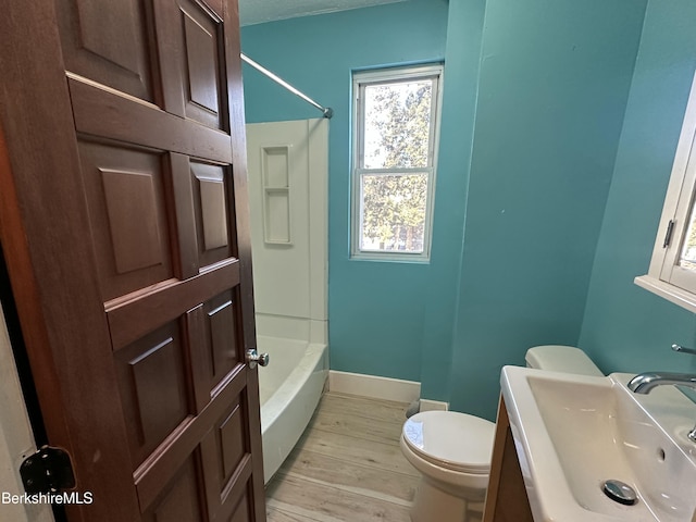 full bathroom featuring sink, wood-type flooring, shower / bathtub combination, and toilet