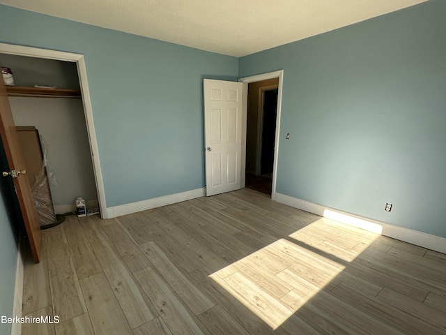 unfurnished bedroom with light hardwood / wood-style floors and a closet