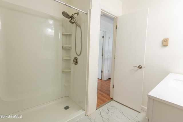 bathroom with a stall shower, marble finish floor, and vanity