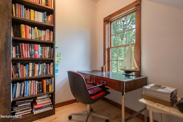 office area with a wealth of natural light, wood finished floors, and baseboards