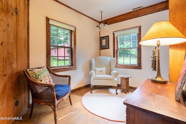sitting room with baseboards, hardwood / wood-style flooring, visible vents, and crown molding