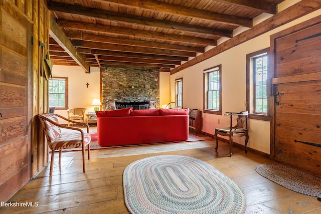 sitting room with beamed ceiling, wooden ceiling, a healthy amount of sunlight, and wood-type flooring
