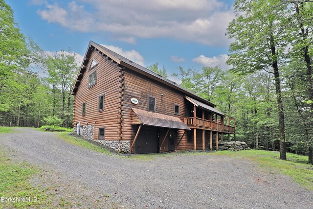 233 Algerie Rd, Becket, MA 01223 - view of front of house with a wooden deck, log siding, and stone siding