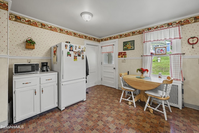 15 Summit Ave, Adams, MA 01220 - kitchen featuring freestanding refrigerator, wallpapered walls, black microwave, brick patterned floors, and white cabinetry