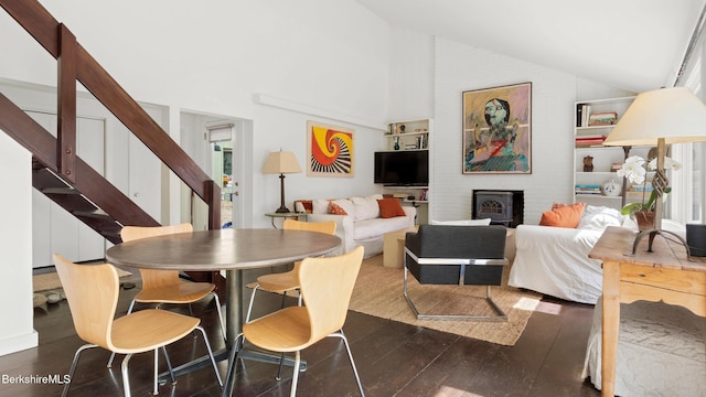 dining space with stairs, high vaulted ceiling, and dark wood-style floors