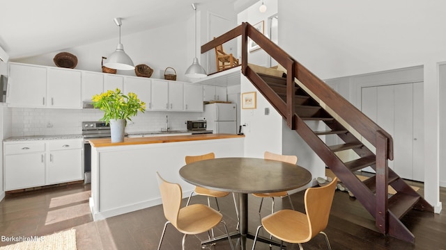 kitchen with decorative backsplash, white cabinetry, high vaulted ceiling, and stainless steel appliances