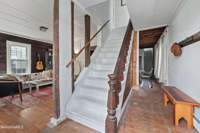 stairs with hardwood / wood-style flooring and wood walls