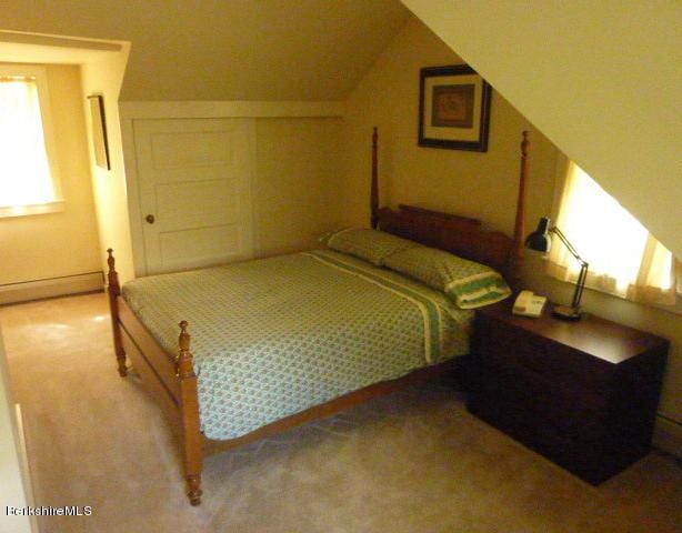 carpeted bedroom with baseboard heating