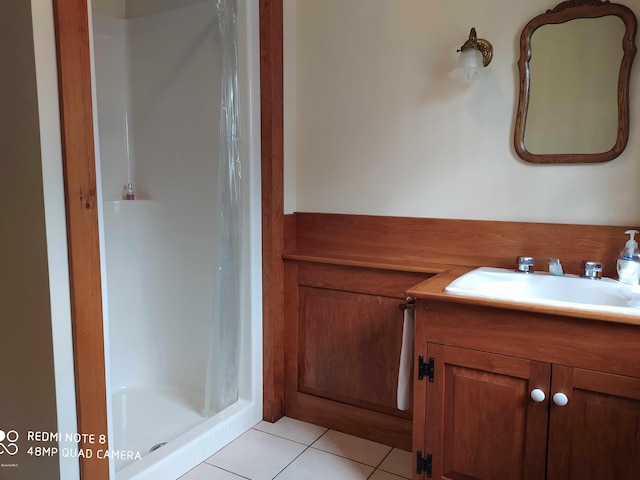 bathroom with tile patterned floors, vanity, and a shower