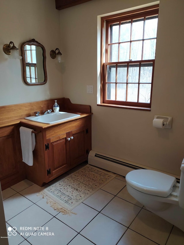 bathroom with toilet, vanity, tile patterned floors, and baseboard heating