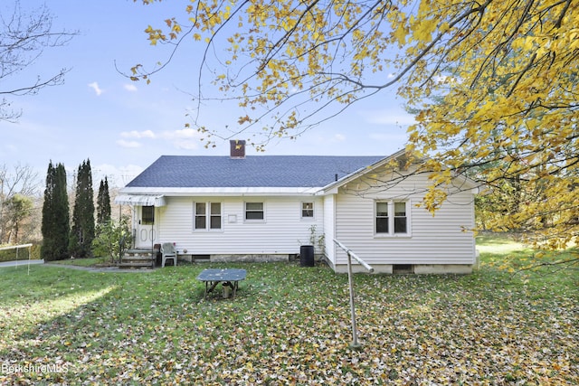 back of property with a lawn and central air condition unit