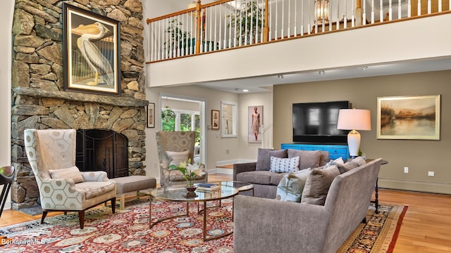 13 Taconic Ave, Lenox, MA 01240 - living room with a fireplace, wood finished floors, a baseboard heating unit, and a high ceiling