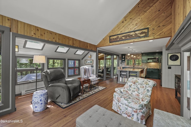 171 Lake Shore Dr, Otis, MA 01253 - living room featuring a baseboard radiator, high vaulted ceiling, wood walls, wood finished floors, and a skylight