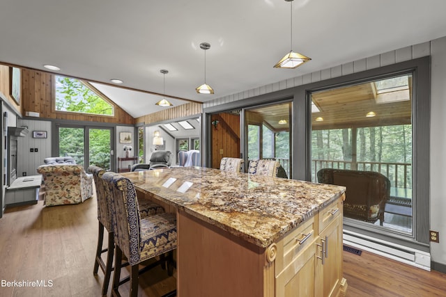 171 Lake Shore Dr, Otis, MA 01253 - kitchen with open floor plan, light stone counters, lofted ceiling, wood finished floors, and a kitchen island