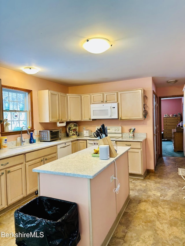 kitchen featuring a toaster, light countertops, a kitchen island, a sink, and white appliances