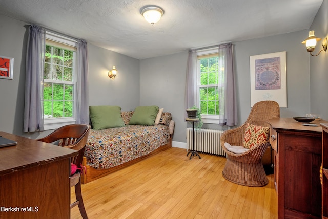 160 Marion Ave, North Adams, MA 01247 - bedroom with radiator, wood-type flooring, multiple windows, and a textured ceiling