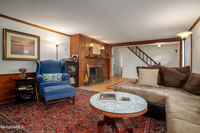 160 Marion Ave, North Adams, MA 01247 - living room featuring stairway, wood finished floors, a fireplace with flush hearth, crown molding, and wooden walls