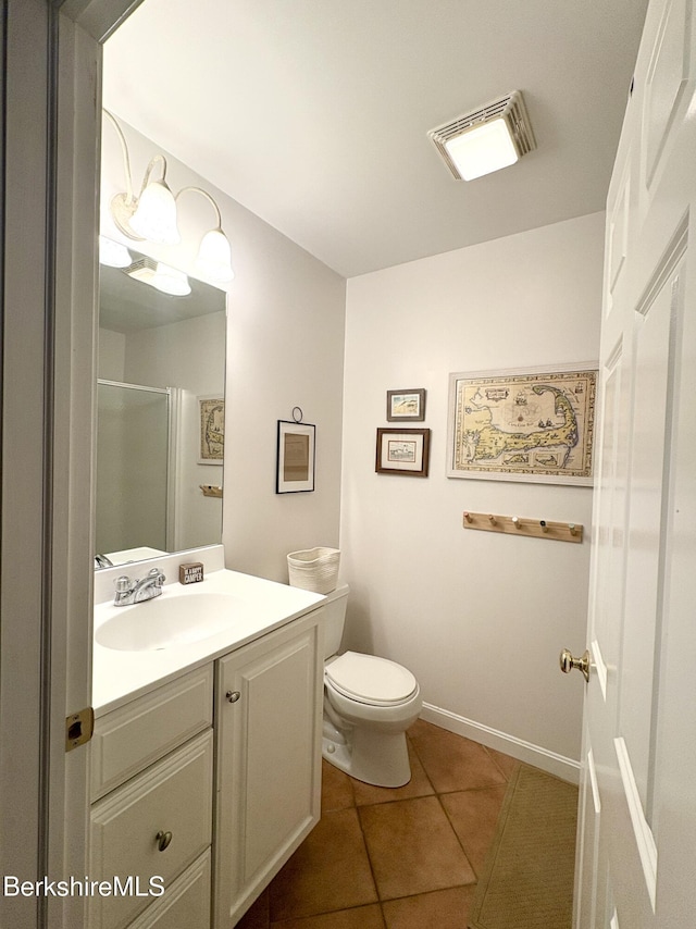 bathroom with tile patterned flooring, vanity, toilet, and a shower with shower door