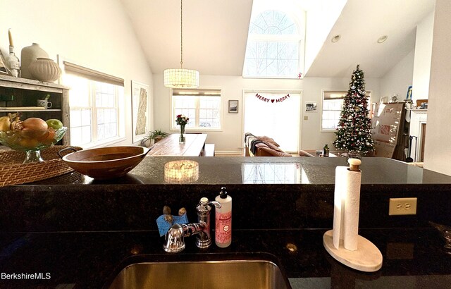 kitchen with pendant lighting, high vaulted ceiling, and sink