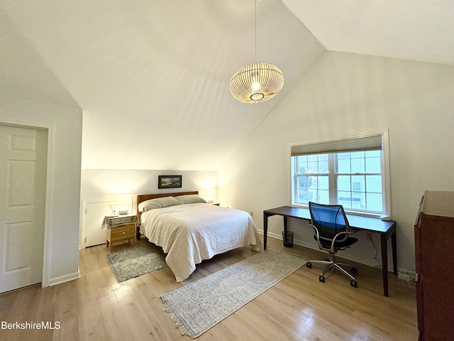 bedroom featuring light hardwood / wood-style floors and vaulted ceiling