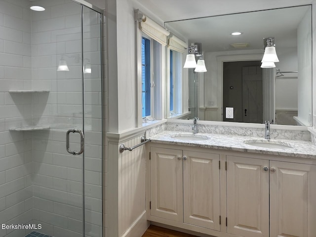 full bathroom with a shower stall and double vanity