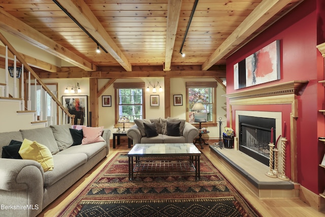 169 Jacobs Hollow Rd, Becket, MA 01223 - living area featuring wood finished floors, a wood ceiling with exposed beams, a fireplace with raised hearth, stairs, and track lighting